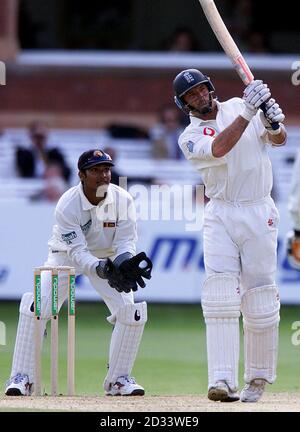 Englands Kapitän Nasser Hussain sticht Mitte des Tages für 6 Läufe, während Sri Lankas Wicketkeeper Kumar Sangakkara auf den vierten Tag des ersten npower Test Match am Lords Cricket Ground schaut. Stockfoto