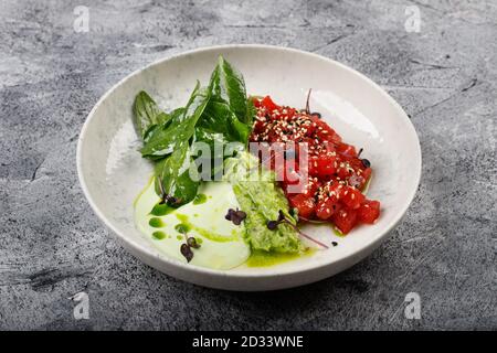 Exquisites Thunfischfilet mit rohem Fischtartar und grünem Gemüse aus nächster Nähe Auf einem weißen Teller Stockfoto