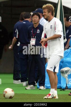 Der englische David Beckham spürt die Schmerzen, nachdem der Ball seine Hand beim Training im Nagai Stadium in Osaka, Japan, vor dem Spiel der World Cup Game Group F zwischen England und Nigeria am Mittwoch getroffen hat. England braucht sich nur zu ziehen, um sich ihren Platz in den letzten 16 zu sichern. Eiwc Stockfoto