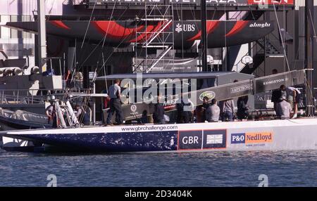 Großbritanniens America's Cup Team GBR Challenge segelt auf ihrer Yacht Wight Lightning an der Alinghi-Basis in Auckland, Neuseeland vorbei, während sie sich auf den Weg zum Hauraki-Golf machen, um sich den Favoriten aus der Schweiz zu stellen. Stockfoto