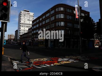 Leicester, Leicestershire, Großbritannien. Oktober 2020. Ein Mann geht auf Fußgängerüberwegen, die 100 Tage nach der UKÕs Ankündigung der ersten lokalen Coronavirus-Pandemiesperre in der Stadt mit bunten Abdeckungen umgestaltet wurden. Credit Darren Staples/Alamy Live News. Stockfoto