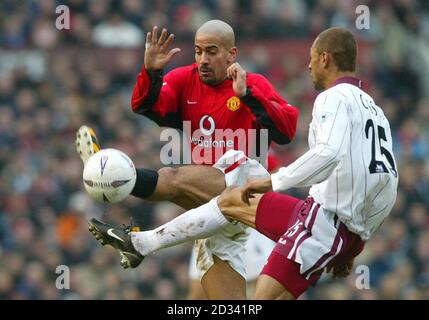 Manchester Uniteds Juan Veron kämpft mit West Ham United's Edouard Cisse (rechts) während ihres FA Cup vierten Runde Spiel in Old Trafford, Manchester. DIESES BILD KANN NUR IM RAHMEN EINER REDAKTIONELLEN FUNKTION VERWENDET WERDEN. KEINE WEBSITE-/INTERNETNUTZUNG, ES SEI DENN, DIE WEBSITE IST BEI DER FOOTBALL ASSOCIATION PREMIER LEAGUE REGISTRIERT. Stockfoto