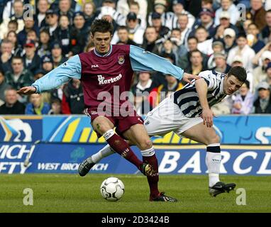 West Ham United's Michael Carrick zwickt mit West Bromwich Albion's Jason Koumas (rechts) während ihres Barclaycard Premiership Matches gegen West Ham United in den Hawthorns, West Bromich. West Ham United besiegte West Bromwich Albion 2:1. DIESES BILD KANN NUR IM RAHMEN EINER REDAKTIONELLEN FUNKTION VERWENDET WERDEN. KEINE WEBSITE-/INTERNETNUTZUNG, ES SEI DENN, DIE WEBSITE IST BEI DER FOOTBALL ASSOCIATION PREMIER LEAGUE REGISTRIERT. Stockfoto