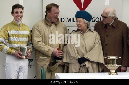 Die britische Königin Elizabeth II. Überreicht die Siegertrophäe an (von links nach rechts) Jockey, LT Alex Michael, Trainer Pat Chamings und Besitzer Ron Shaw bei der Präsentation des Alvis Grand Military Gold Cup im Sandown Park, wo die Königin auch die Statue ihrer Mutter enthüllte. Stockfoto