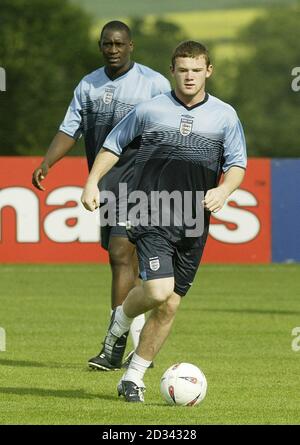 Der englische Wayne Rooney (rechts) in Aktion mit Teamkollege Emile Heskey beim Blick auf (links) während eines Teamtrainings in Champney's Springs, Leicestershire, zur Vorbereitung auf Englands internationales Freundschaftsspiel gegen Serbien und Montenegro im Walkers Stadium von Leicester City. Stockfoto