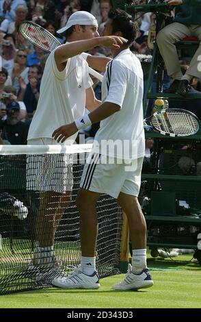 NUR FÜR REDAKTIONELLE ZWECKE, KEINE VERWENDUNG VON MOBILTELEFONEN. Andy Roddick aus den USA umarmt den Thailänder Paradorn Srichaphan, nachdem er ihn beim vierten Lauf der All England Lawn Tennis Championships in Wimbledon 6:2:4/3:6/6:3/6 aus dem Rennen geschlagen hat. Stockfoto