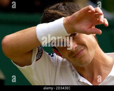 Der britische Tim Henman auf dem Center Court, bevor er im Viertelfinale der Männer bei den All England Lawn Tennis Championships in Wimbledon gegen Sebastien Grosjean aus Frankreich (links) verlor. * das Spiel wurde wieder aufgenommen, nachdem es aufgrund von Regenunterbrechungen und schlechtem Licht abgebrochen wurde. Henman verlor schließlich 7:6/3:6/6:3/6:4. Stockfoto