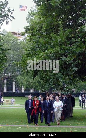 Der US-amerikanische Geschäftsträger David Johnson (in der Mitte, blauer Anzug) kommt an, um bei einer Zeremonie in den Memorial Gardens, Grosvenor Square, vor der amerikanischen Botschaft, London, einen Kranz zu legen, um an den dritten Jahrestag der Terroranschläge von 9/11 zu erinnern. Stockfoto