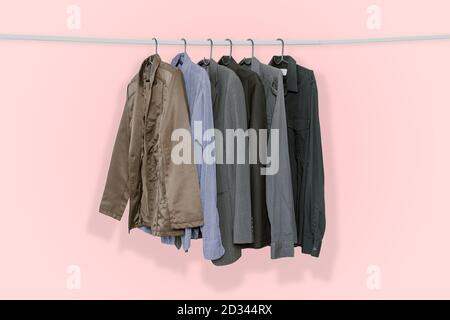 Herrenanzüge und Jacken auf Kleiderbügel isoliert auf rosa Pastellfarben Hintergrund, mit Clipping Pfad gehängt. Stockfoto