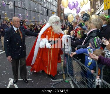 Harrods Vorsitzender Mohamed Al Fayed (links) und Father Christmas treffen während einer Parade vor dem Laden in Knightsbridge, London, Mitglieder der Öffentlichkeit, bevor sie die Santa-Grotte öffnen. Stockfoto