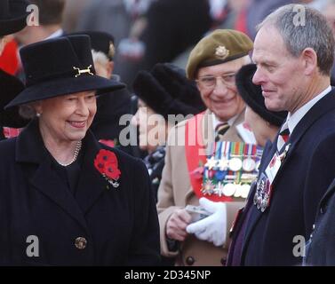 Die britische Königin Elizabeth II. Trifft Veteranen nach einem Gottesdienst zum Waffenstillstandstag im Field of Remembrance auf dem Gelände der Londoner Westminster Abbey. Hunderte von kleinen Holzkreuzen, die auf dem Gelände der Abtei gepflanzt und mit einem blutroten Mohn geschmückt sind, tragen den Namen eines gefallenen Liebsten und die Botschaft des Gedenkens. Stockfoto