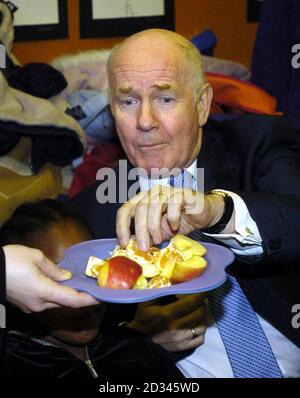 Gesundheitsminister Dr. John Reid besucht eine Klasse junger Schüler an einer Schule im Süden Londons, wo Kinder Obst als Teil des Gesundheitsministeriums erhalten. Ein heute angekündigtes Weißbuch zur öffentlichen Gesundheit enthält eine Reihe von Maßnahmen, um Erwachsene und Kinder zu mehr Bewegung und einer gesünderen Ernährung zu ermutigen. Stockfoto