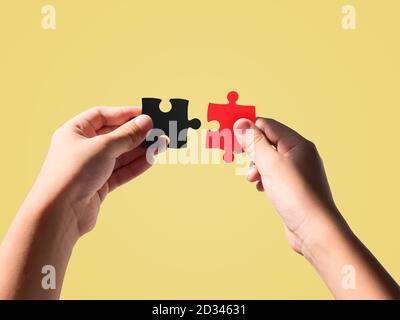 Hände halten schwarz und rot Farbe Stichsägen isoliert auf schönen Pastellfarben Hintergrund. Stockfoto