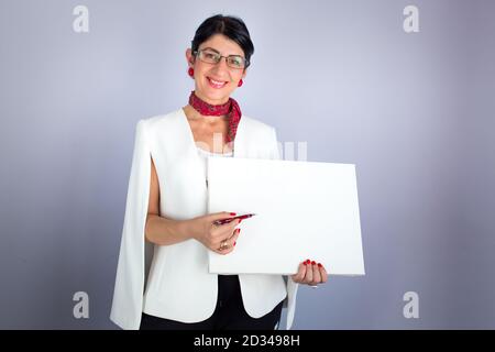 Elegante Brünette Lehrer zeigt etwas auf leeren weißen Brett. Online-Lernen Stockfoto