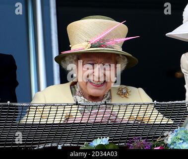 Königin Elizabeth II lächelt, als das Goldene Horn von Frankie Dettori nach dem Gewinn des Investec Derby am Derby Day des Investec Derby Festivals 2015 auf der Epsom Racecourse, Epsom, an der Spitze steht. Stockfoto