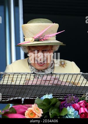 Königin Elizabeth II lächelt, als das Goldene Horn von Frankie Dettori nach dem Gewinn des Investec Derby am Derby Day des Investec Derby Festivals 2015 auf der Epsom Racecourse, Epsom, an der Spitze steht. Stockfoto