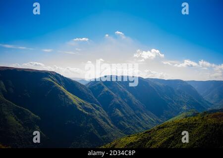 Natürlicher Blick auf die gefalteten Berge und üppig grüne Täler mit klarem Himmel und Wolken von Cherrapunji, Meghalaya, Nordostindien Stockfoto