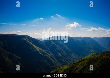 Natürlicher Blick auf die gefalteten Berge und üppig grüne Täler mit klarem Himmel und Wolken von Cherrapunji, Meghalaya, Nordostindien Stockfoto