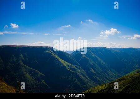 Natürlicher Blick auf die gefalteten Berge und üppig grüne Täler mit klarem Himmel und Wolken von Cherrapunji, Meghalaya, Nordostindien Stockfoto