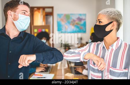 Junge Mitarbeiter stoßen ihre Ellbogen, anstatt mit einem Handschlag zu grüßen - vermeiden Sie die Ausbreitung von Coronavirus, sozialer Distanz und Freundschaftskonzept - FOC Stockfoto