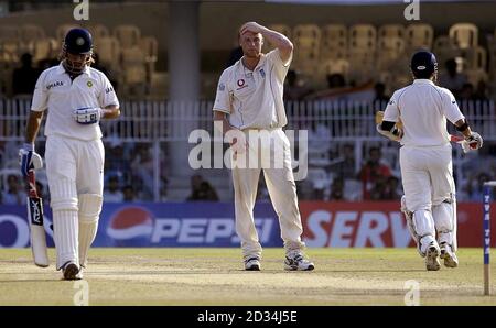 Der indische Schlagmann Mahendra Dhoni (links) und Sachin Tendulkar erzielen vier Läufe, beobachtet vom englischen Kapitän Andrew Flintoff (C) am fünften Tag des ersten Testmatches am Vidarbha Cricket Association Ground, Nagpur, Indien, Sonntag, 5. März 2006. Das erste Testspiel endete mit einer Verlosung. Siehe PA Geschichte CRICKET England. DRÜCKEN SIE VERBANDSFOTO. Bildnachweis sollte lauten: Rebecca Naden/PA. *** - KEINE HANDY-NUTZUNG*** Stockfoto