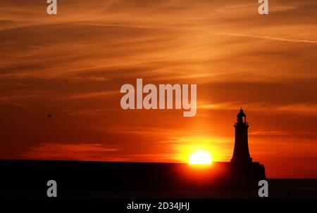 Die Sonne geht über Tynemouth Leuchtturm in Tyne and Wear am letzten Tag bevor die Uhren vorwärts zu gehen. Stockfoto