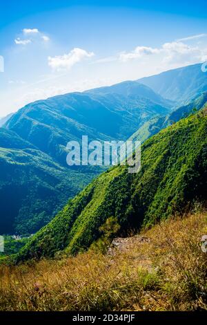 Natürlicher Blick auf die gefalteten Berge und üppig grüne Täler mit klarem Himmel und Wolken von Cherrapunji, Meghalaya, Nordostindien Stockfoto