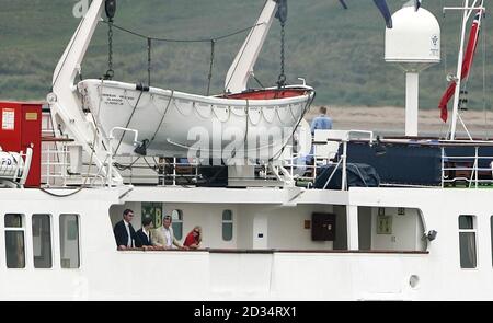 Die Prinzessin Royal, ihr Mann Konteradmiral Tim Laurence, ihr Sohn Peter Phillips und seine Freundin Autumn Kelly schauen vom Deck, als die Hebridenprinzessin Port Ellen auf Islay verlässt, um mit ihrer Familie eine einwöchige Kreuzfahrt um die Westlichen Inseln zu machen, um ihren 80. Geburtstag zu feiern. Stockfoto