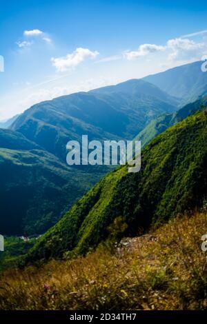 Natürlicher Blick auf die gefalteten Berge und üppig grüne Täler mit klarem Himmel und Wolken von Cherrapunji, Meghalaya, Nordostindien Stockfoto