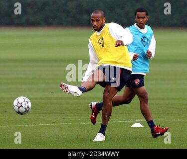 Thierry Henry von Arsenal passiert den Ball, während Theo Walcott (rechts) während einer Trainingseinheit in London Colney, Hertfordshire, schaut. Stockfoto