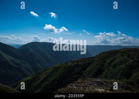 Natürlicher Blick auf die gefalteten Berge und üppig grüne Täler mit klarem Himmel und Wolken von Cherrapunji, Meghalaya, Nordostindien Stockfoto