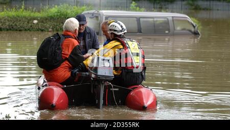 Bewohner, die über Nacht in ihren Häusern gefangen waren, werden heute in der Nähe von Rotherham von Feuerwehrbooten gerettet. Stockfoto