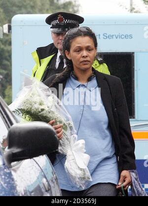 Eine namenlose Frau legt vor dem Haus in Fallowfield, Manchester, mit Tränen Blumen, wo drei Leichen gefunden wurden. Stockfoto