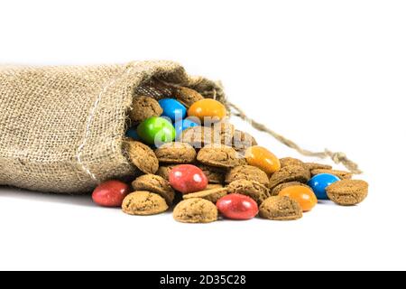 Bunte pepernoten behandelt in Jute Tasche auf weißem Hintergrund für die jährliche Sinterklaas holiday Event in den Niederlanden am 5. Dezember Stockfoto