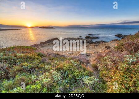 Peloponnes Küste bei Skala bei Sonnenaufgang mit felsigen Ufer und Küstenvegetation Stockfoto