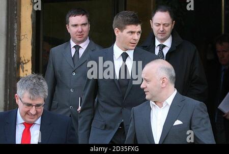 Fußballspieler Steven Gerrard (Mitte rechts) verlässt das North Sefton Magistrate Court, nachdem eine Angriffsanwaltschaft gegen ihn fallen gelassen wurde. Stockfoto