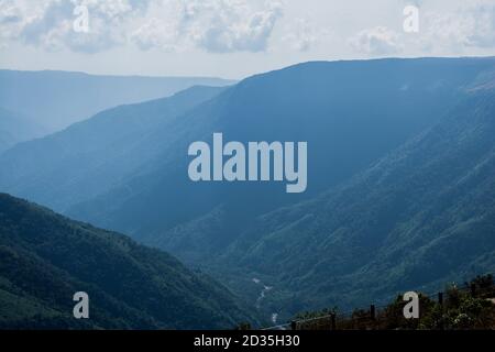 Natürlicher Blick auf die gefalteten Berge und üppig grüne Täler mit klarem Himmel und Wolken von Cherrapunji, Meghalaya, Nordostindien Stockfoto