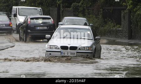 Autos machen ihren Weg durch einen überfluteten Abschnitt der Santry Avenue in Dublin. Stockfoto