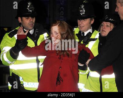 Die Protestantin Grace McCann wird von der Polizei vor dem Queen Elizabeth II Conference Center in London zurückgehalten, nachdem der frühere Premierminister Tony Blair vor der Irakuntersuchung aufstand. Stockfoto