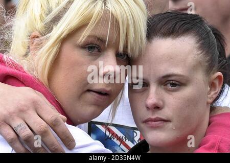 Cheryl Edgar (rechts), Freundin von Sapper Daryn Roy, 28, und ein unbenanntes Mädchen beobachten als Leichenwagen mit den Särgen von Sapper Daryn Roy, Lance Corporal Barry Buxton und Corporal Harvey Holmes durch die Stadt Wootton Bassett nach ihrer Rückführung bei RAF Lyneham in Wiltshire. Stockfoto