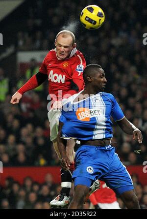 Wayne Rooney von Manchester United springt mit Steve Gohouri von Wigan (rechts) während des Spiels der Barclays Premier League in Old Trafford, Manchester. Stockfoto