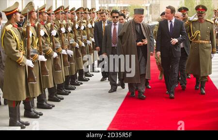 Premierminister David Cameron (vorne rechts) und der afghanische Präsident Hamid Karzai (vorne links) passieren eine Ehrenwache vor ihren Gesprächen in Kabul, Afghanistan. Stockfoto