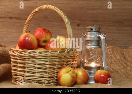Korb mit roten gelben Äpfeln und einer Lampe auf einem Tabelle Stockfoto