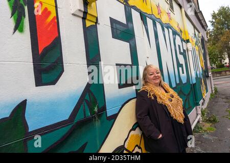 Glasgow, Schottland, Großbritannien. Oktober 2020. Das Time Out Magazin hat Dennistoun im East End von Glasgow zu einem der coolsten Viertel der Welt gekürt. Im Bild: Anne McLaughlin, SNP-Abgeordnete des Wahlkreises Glasgow North East, posiert nach der neuen Anerkennung des Bezirks vor einem Wandgemälde in Dennistoun. Iain Masterton/Alamy Live News Stockfoto