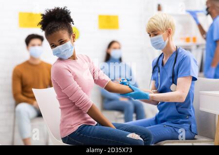Arzt Impfen Schwarz Teen Mädchen Gegen Coronavirus Sitzt Im Krankenhaus Stockfoto