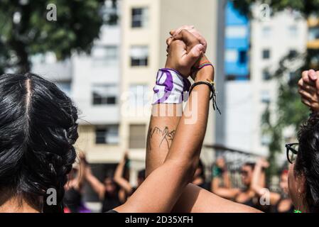 Die erhobenen Hände von 2 Frauen aus dem "Wir sind 2074' Aktivistengruppe marschiert und tanzt in den Straßen hinein Solidarität am Internationalen Frauentag 2020 Stockfoto