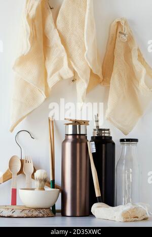 Ein Stapel von nachhaltigen Haushaltsgegenständen ohne Plastik, wie nachfüllbare Wasserflaschen, eine Glasflasche, Shopping-Mesh-Taschen, eine Rasierpinsel aus Holz und auch Stockfoto