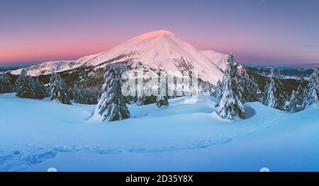 Fantastische orange Winterlandschaft in Snowy Mountains glühende durch Sonnenlicht. Dramatische winterliche Szene mit verschneiten Bäumen. Weihnachten Hintergrund Stockfoto