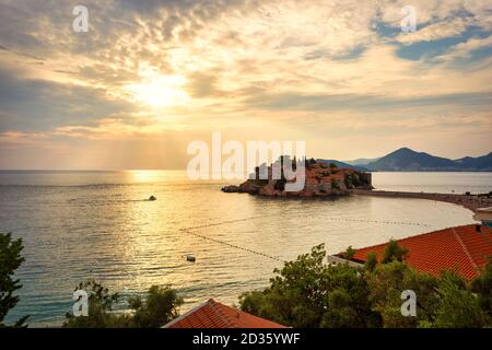 Fantastischer Sonnenuntergang über Luxusstrand und Insel Sveti Stefan in der Nähe von Budva in Montenegro (Adria), Europa. Reisekonzept, Hintergrund. Stockfoto