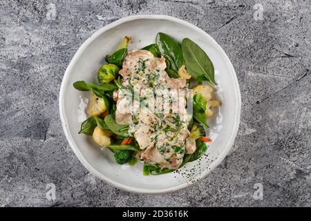 Huhn in Sahne-Sauce mit Broccoli, Blumenkohl, Basilikum und Rosmarin Stockfoto